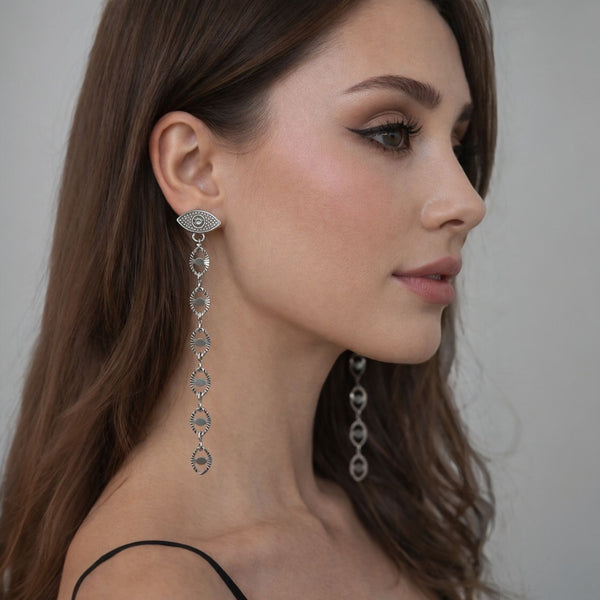 Woman wearing elegant silver earrings with a neutral background fringe tassel