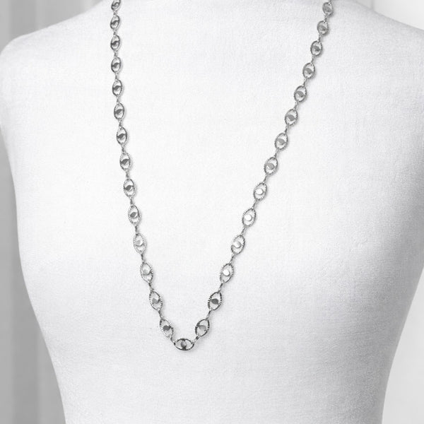 Silver chain necklace on a mannequin with a plain background