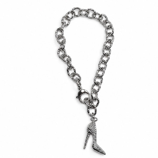 A silver-tone chain bracelet featuring a textured high-heeled shoe charm, displayed on a clean white background.