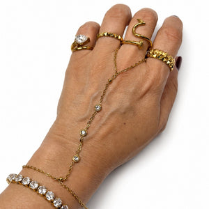 Yellow gold Margot Crystal Hand Chain styled on a hand with rings and a tennis bracelet