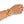 A close-up of a person's wrist wearing two gold-toned bracelets, including a bangle with a raised bird motif, against a plain white background.