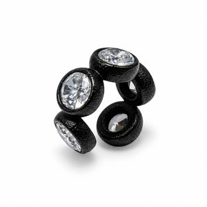 A black textured ear cuff featuring four bezel-set oval clear gemstones, photographed on a clean white background.
