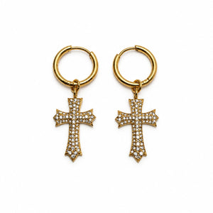 A pair of gold hoop earrings with dangling cross charms paved with small clear stones, shown on a plain white background.