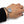 A silver chain bracelet with a large oval clear crystal gemstone, shown worn on a person's wrist against a white background.