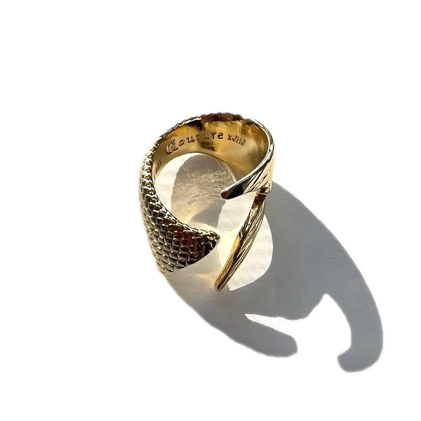 Gold ring with textured design on a white background
